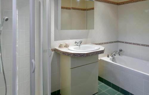 a white bathroom with a sink and a bath tub at Beautiful Home In Yèvre-La-Ville in Yèvre-la-Ville