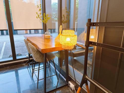 a wooden table with a yellow lamp on top of it at Urban Suites, Signature Collection by Stellar ALV in Jelutong