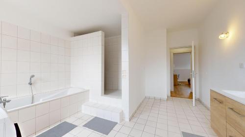 une salle de bain blanche avec une baignoire et un lavabo dans l'établissement Le Carré Mulhousien, à Mulhouse