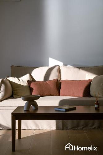 a living room with a couch with pillows on it at AMAYA - Sea View Suites in Chalkida