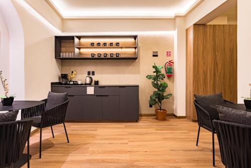 a restaurant with a table and chairs and a kitchen at Suites Monterrey by Escajal Rooms in Mexico City