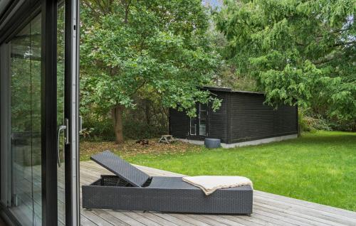 a chair sitting on a deck next to a yard at Awesome Home In Stege With Kitchen in Stege