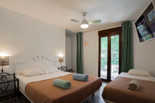 two beds in a bedroom with green curtains at Eco-hotel Aire de Monte in Náquera