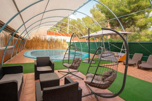 a tent with chairs and a swimming pool at Eco-hotel Aire de Monte in Náquera