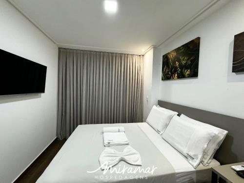 a small bedroom with a bed with a tv on the wall at Move - Tambaú in Tambaú