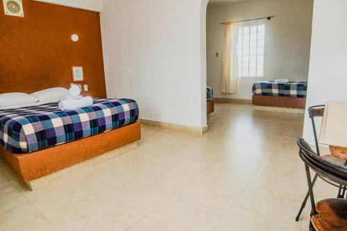 a bedroom with a bed and a table in it at Hotel Espor CA in Barinas