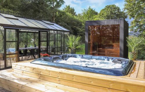 a hot tub on a wooden deck next to a house at Amazing Home In Grindsted With Sauna in Grindsted