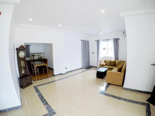 a living room with a couch and a clock at Sambo White House Hikkaduwa - 5BD Entire Villa in Galle