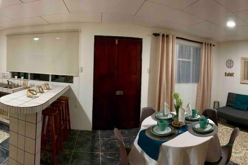 a living room with a table with chairs and a kitchen at Country house with an incredible view to the city in Cartago