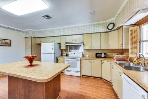 a large kitchen with white appliances and wooden floors at 8 Mi to Lafayette Dog-Friendly Home with Large Yard in Broussard