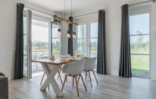 a dining room with a table and chairs and windows at Cozy Apartment In Kamperland in Kamperland