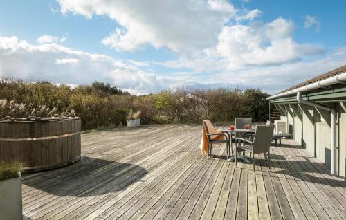Una terraza de madera con una mesa y sillas. en Pet Friendly Home In Blokhus With Wifi, en Blokhus