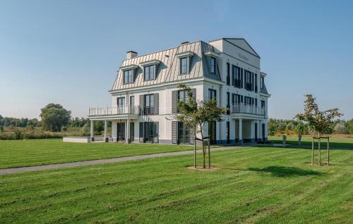 a large white house on a grassy field at Cozy Apartment In Kamperland in Kamperland