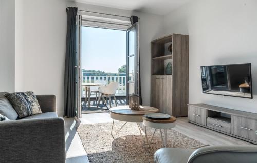a living room with a couch and a television at Cozy Apartment In Kamperland in Kamperland