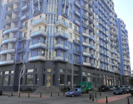 un grande edificio con auto parcheggiate di fronte di Просторная квартира в центре Батуми a Batumi