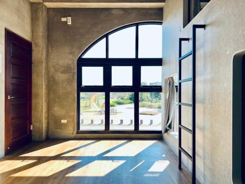 a large window in a room with a large floor to ceiling window at Sasa Youth Hostel in Jiaoxi