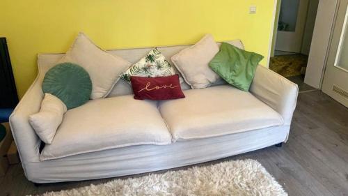 a white couch with pillows on it in a room at Frankfurt am Main 15 Min from Messe, City and ECB in Frankfurt/Main