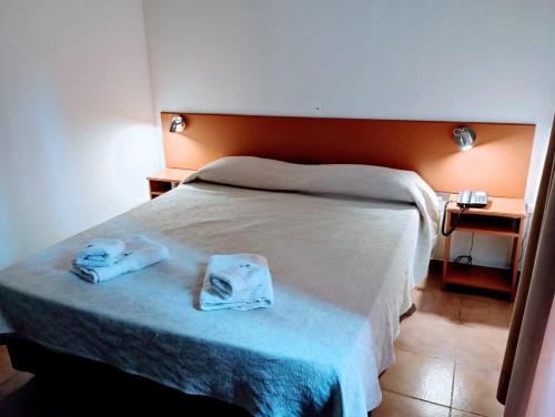 a bedroom with a bed with two towels on it at Apart Hotel Guarumba in Federación