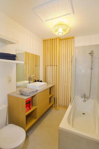 une salle de bain avec une baignoire, un lavabo et des toilettes dans l'établissement La Jungle d'Uzès, à Uzès