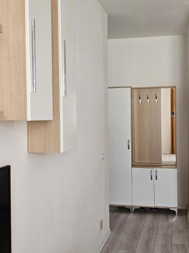 a kitchen with white cabinets and a refrigerator at EraVision Apartament in Yzberishti