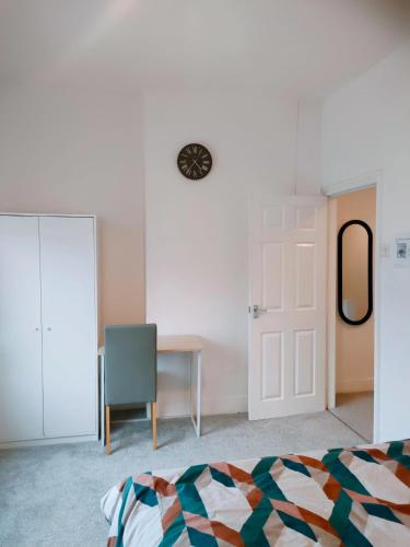 a bedroom with a bed and a desk and a mirror at Spacious House, Near Haigh Woodland Park, Wifi, Parking in Leigh