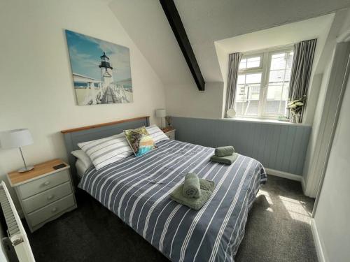a bedroom with a bed with two towels on it at Marigold Cottage in West Down