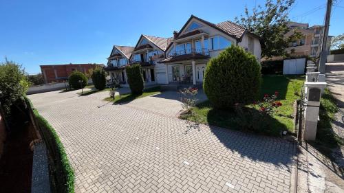 a house with a brick driveway in front of it at Vizbeg Inn in Skopje