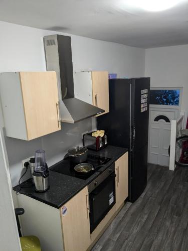 a kitchen with a black stove and a refrigerator at Druid Space in Saint Peters