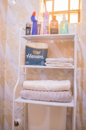 a towel rack with towels and other items in a bathroom at Zuri Home-Kimana in Kimana