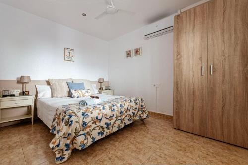 a bedroom with a bed and a wooden cabinet at Casa Marinera en Palamós in Palamós