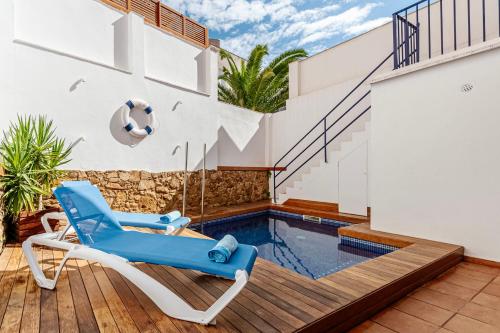 a villa with a swimming pool and a blue chair at Casa Marinera en Palamós in Palamós