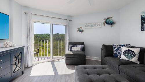 a living room with a couch and a sliding glass door at Blue Haven Key LargoOcean Pointe 1315 in Key Largo