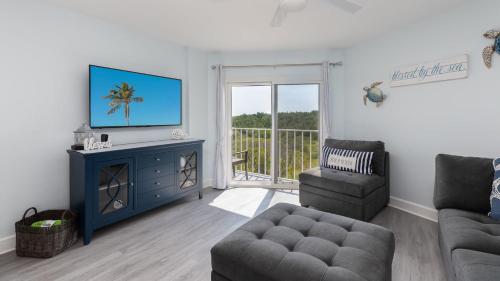 a living room with a flat screen tv and a couch at Blue Haven Key LargoOcean Pointe 1315 in Key Largo