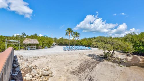 a beach with a bunch of chairs and palm trees at Blue Haven Key LargoOcean Pointe 1315 in Key Largo