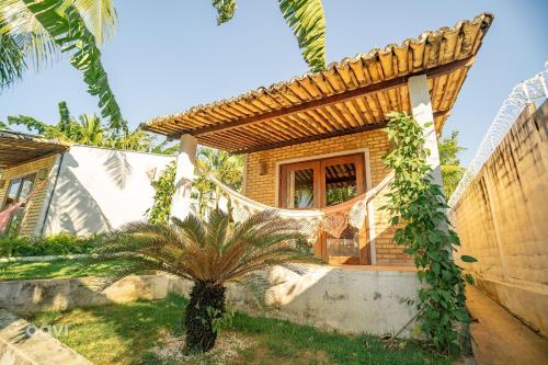 a house with a palm tree in the yard at Qavi - Lagoa View in Pipa