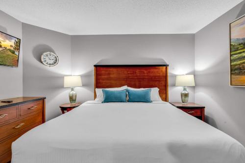 a bedroom with a large white bed with blue pillows at Oceanfront Perfect Couples Getaway in Myrtle Beach