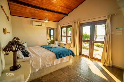 a bedroom with a bed and a large window at Qavi - Lagoa View in Pipa