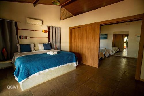 a bedroom with a large bed with a blue blanket at Qavi - Lagoa View in Pipa