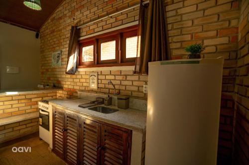 a kitchen with a sink and a refrigerator at Qavi - Lagoa View in Pipa