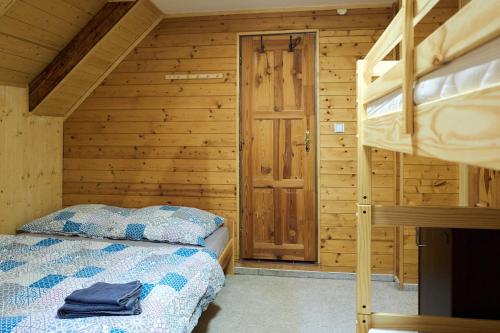 a bedroom with a bunk bed in a wooden cabin at HORSKÝ PENZION U SPLAVU in Josefuv dul