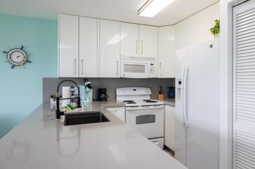 a kitchen with white cabinets and a white refrigerator at Paradise Palms Ocean Pointe 1206 in Key Largo