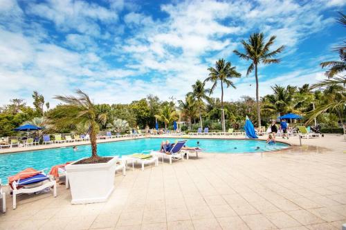 ein Pool in einem Resort mit Stühlen und Palmen in der Unterkunft It's Island Time in the Keys Double King Ensuites 2 Balconies in Key Largo