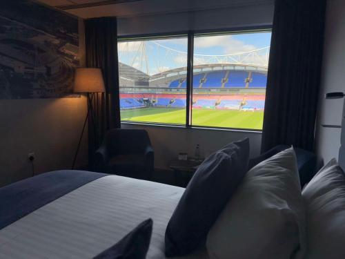 a hotel room with a bed with a view of a stadium at The Bolton Stadium Hotel, a member of Radisson Individuals in Bolton