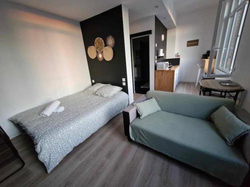 a living room with a bed and a couch at Studio Canada 3 in Valenciennes
