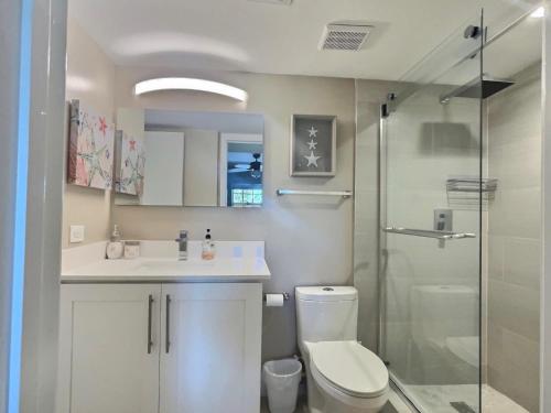 a bathroom with a toilet and a sink and a shower at Key Largo Sunrise Resort Style Ocean Pointe 5315 in Key Largo
