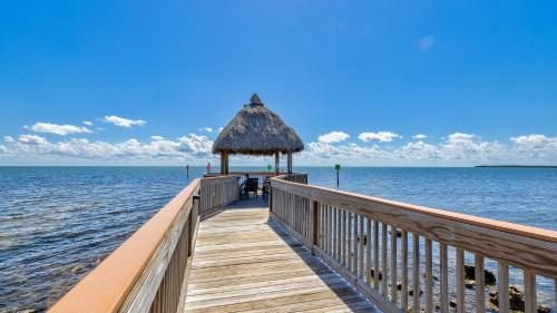 a wooden pier with a hut on the water at Key Largo Sunrise Resort Style Ocean Pointe 5315 in Key Largo