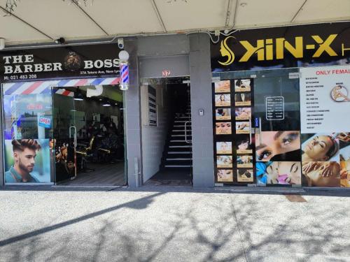 a store front of a store with posters on the windows at 5 Beds including 1 Double Bed, 2 single Beds, 2 Double Sofa Beds, Suite 4, 37 Totara Avenue, New Lynn in Auckland