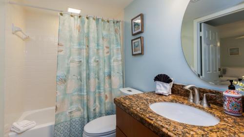 a bathroom with a sink and a toilet and a mirror at Reel Key Largo Escape Ocean Pointe 5209 in Key Largo