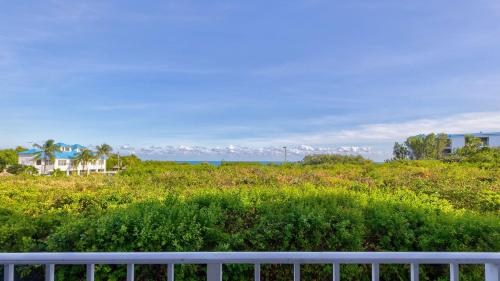 a white fence in a field with a house at Reel Key Largo Escape Ocean Pointe 5209 in Key Largo