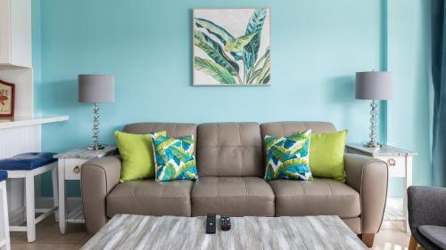 a living room with a brown couch with green pillows at Boho Chic Ocean Pointe 3214 in Key Largo